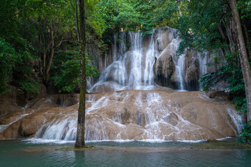 Sai Yok Noi Waterfall in Kanchanaburi, Thailand, is a charming spot surrounded by lush forest, a gentle cascade, peaceful nature, and beautiful scenery.
