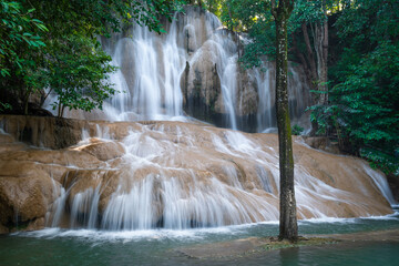 Sai Yok Noi Waterfall in Kanchanaburi, Thailand, is a charming spot surrounded by lush forest, a gentle cascade, peaceful nature, and beautiful scenery.