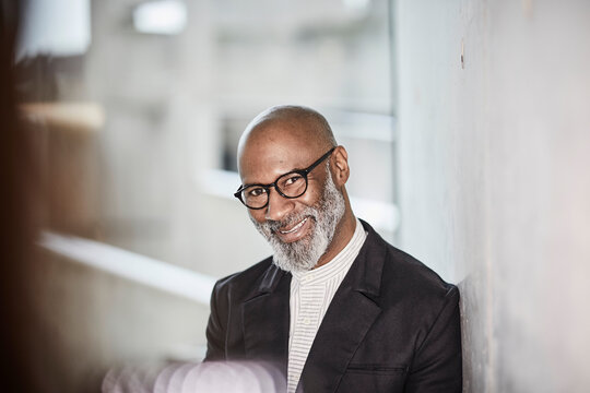 Portrait of smiling mature businessman with grey beard wearing glasses