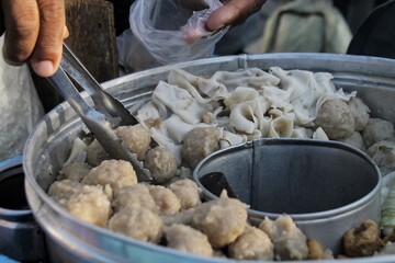 Steaming Dumplings and Dim Sum in a Metal Basket at a Street Food Stall