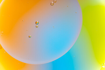 Macro Abstract Background of Oil and Water Bubbles with Orange, Blue, and Neon Yellow Fluid Colors