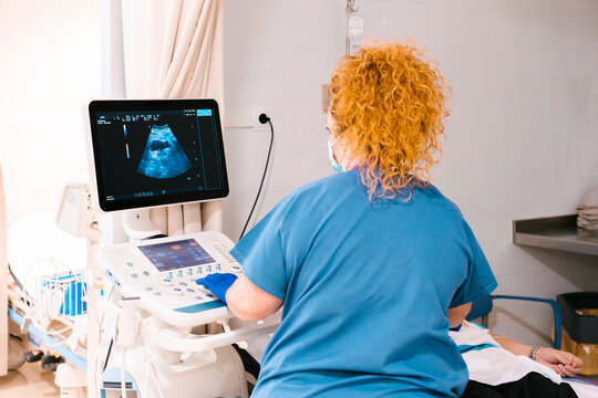 Nurse examining patient through ultrasound machine at hospital
