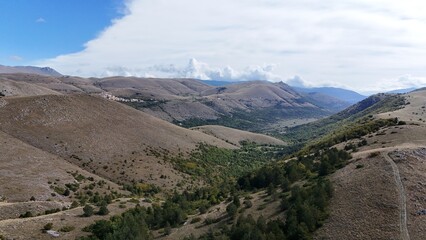 Aerial drone footage of the Abruzzo mountains in Italy, featuring dramatic peaks, rolling hills, and breathtaking natural landscapes