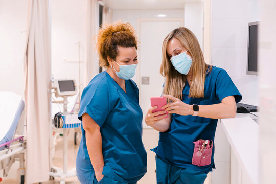 Nurse with colleague using smart phone at hospital