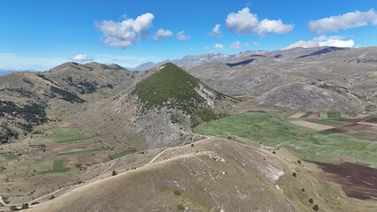Aerial drone footage of the Abruzzo mountains in Italy, featuring dramatic peaks, rolling hills, and breathtaking natural landscapes