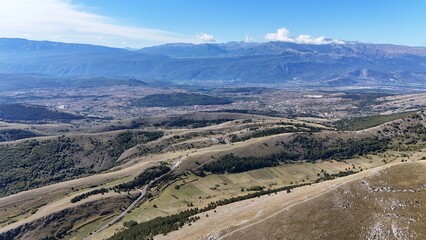 Aerial drone footage of the Abruzzo mountains in Italy, featuring dramatic peaks, rolling hills, and breathtaking natural landscapes
