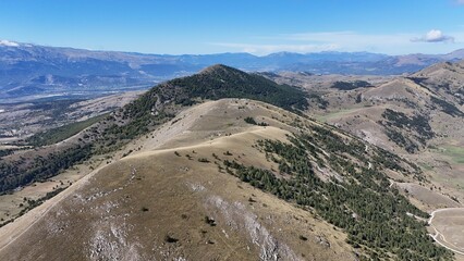 Aerial drone footage of the Abruzzo mountains in Italy, featuring dramatic peaks, rolling hills, and breathtaking natural landscapes