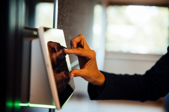 Hand using touchscreen sensor device in modern office meeting room