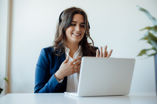 Professional in headset conducting a video call in office environment