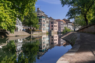 Fototapeta premium Strasbourg, France - August 26th 2025 : View of the Tanner's Quarter with half-timbered buildings and the Ill river and reflections on the water.