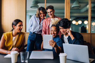 Young adults share ideas on tablet in a creative discussion