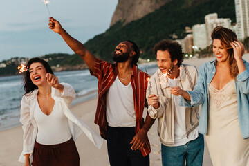 Friends celebrating with sparklers on the beach during an evening gathering