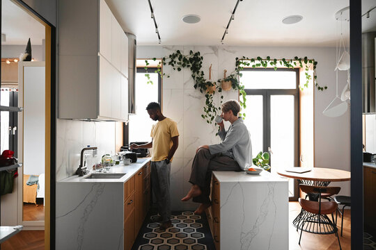 Couple cooking together in modern kitchen during morning