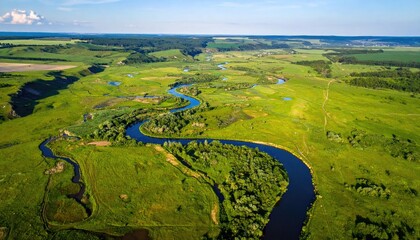 Serpentine river winds through green, grassy valley