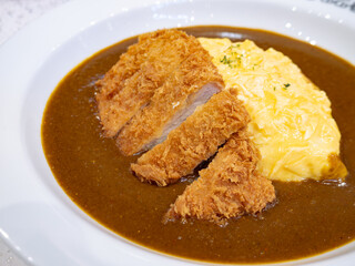 Japanese Pork Cutlet Katsu Curry with Fluffy Omurice Omelette on White Plate