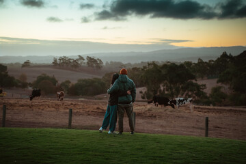 A couple enjoys a beautiful sunset over a tranquil pasture filled with nature