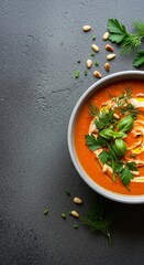 Vibrant Tomato Soup with Herbs and Pine Nuts on Dark Surface.
