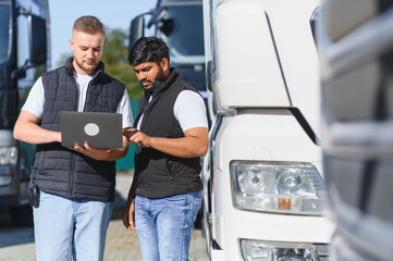Logistics team planning truck routes using laptop