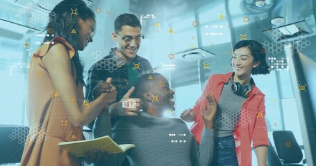 Collaborating tech team brainstorming with seated colleague in office using notebook and pen