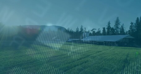 Obraz premium Showing metal-roof barn with silos by green crop field, evergreens and rolling hills, copy space
