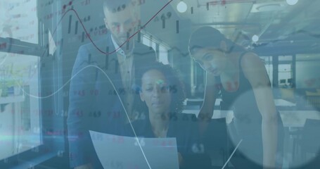 Reviewing colleagues examining printed report in modern office, with charts overlaying monitors