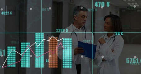 Medical professionals in lab coats reviewing digital charts in hospital hallway, with stethoscopes