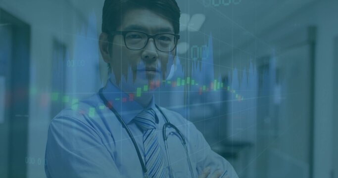 Standing Chinese male doctor crossing arms in hospital hallway, showing candlestick chart overlays