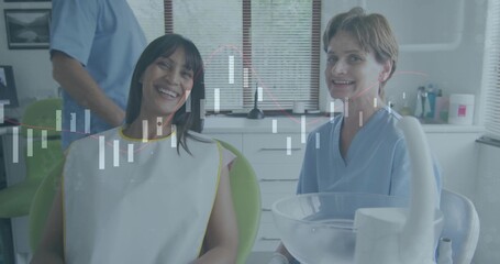 Smiling dentist and patient chatting in dental clinic, with protective bib and suction tube