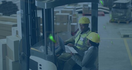 Forklift operator and coworker in safety gear reviewing inventory by forklift in depot, with laptop