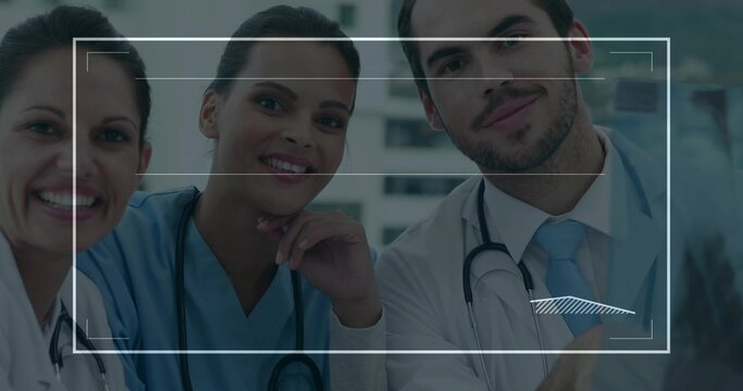 Examining medical team analyzing overlay of x-ray scans on monitor in exam room, with stethoscopes