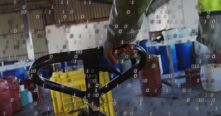 Operating warehouse worker gripping pallet jack handle amid yellow crates and red jerry cans