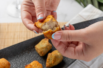 Woman's hands breaking open a hot croquette