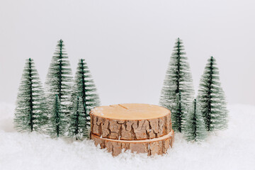 Wooden podium with christmas trees in the snow on white background. Christmas and new year stand for gift, design and product presentation