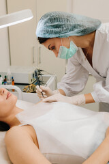 Radiofrequency mole removal under clinical conditions. dermatologist performs precise radio wave mole removal using radiofrequency surgery. Close-up of radio wave dermatologic mole excision.