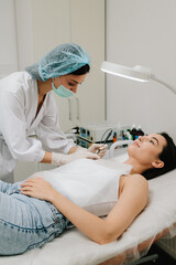 Radiofrequency mole removal under clinical conditions. dermatologist performs precise radio wave mole removal using radiofrequency surgery. Close-up of radio wave dermatologic mole excision.