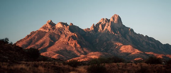 majestic mountain landscape at golden hour with sun kissed rugged peaks and arid terrain
