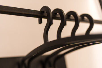 Black plastic clothes hanger in a wardrobe a simple wardrobe. Close up.