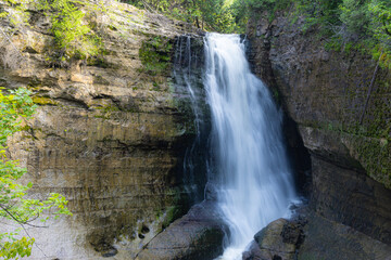 Waterfall cascading over rock ledge in forest