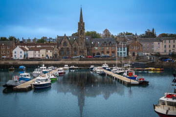 Fototapeta premium Leith skyline and seascape with church spire rising over the Entrance Basin on the North Sea in Scotland.