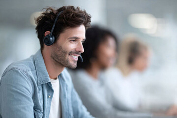 Smiling man with headset in a call center. Represents customer service, support, communication, and teamwork. Ideal for business, technology, and service industries.
