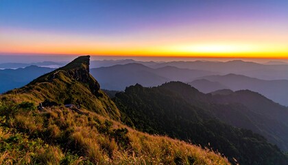 A picturesque mountaintop view showcases a vibrant sunrise over undulating, verdant hills with a gradient sky