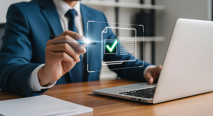Businessman reviewing document on a screen with a green check mark using a laptop at his desk, showing compliance, approval, and quality control