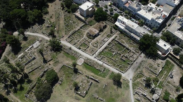 Aerial view of old ruins juxtaposed against newer buildings, blending the ancient with the modern in a textured landscape, Kos, Greece.