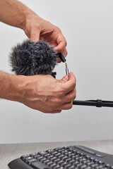 man setting up professional microphone on table at home