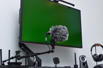 black professional boom microphone stand used for recording voice in online podcast in home studio. fluffy microphone and computer on the table