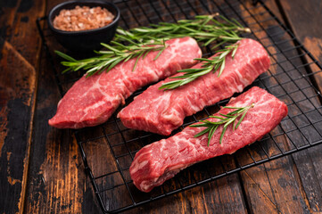 Raw Tri Tip Steak from Black Angus beef meat with rosemary. wooden background. top view