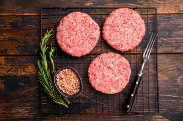 Raw meat patties, cutlets, chopped meat for burgers. wooden background. top view