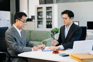 Lawyer advising client on contract signing in modern office, with gavel and scales of justice. Perfect for law, finance, consulting, or business concepts.