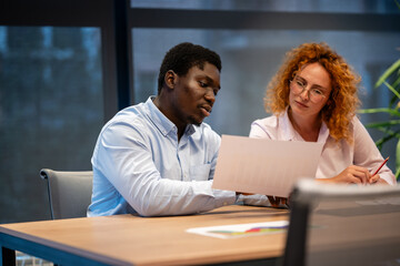 Business colleagues discussing financial report in modern office setting