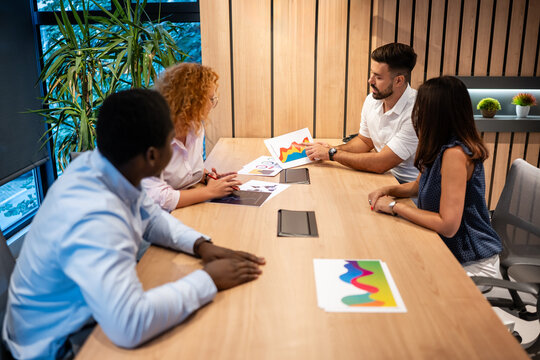 Diverse business team collaborating on colorful data presentation